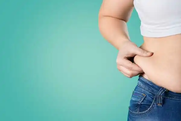Image of woman pinching her love handles to show weight gain Crewe